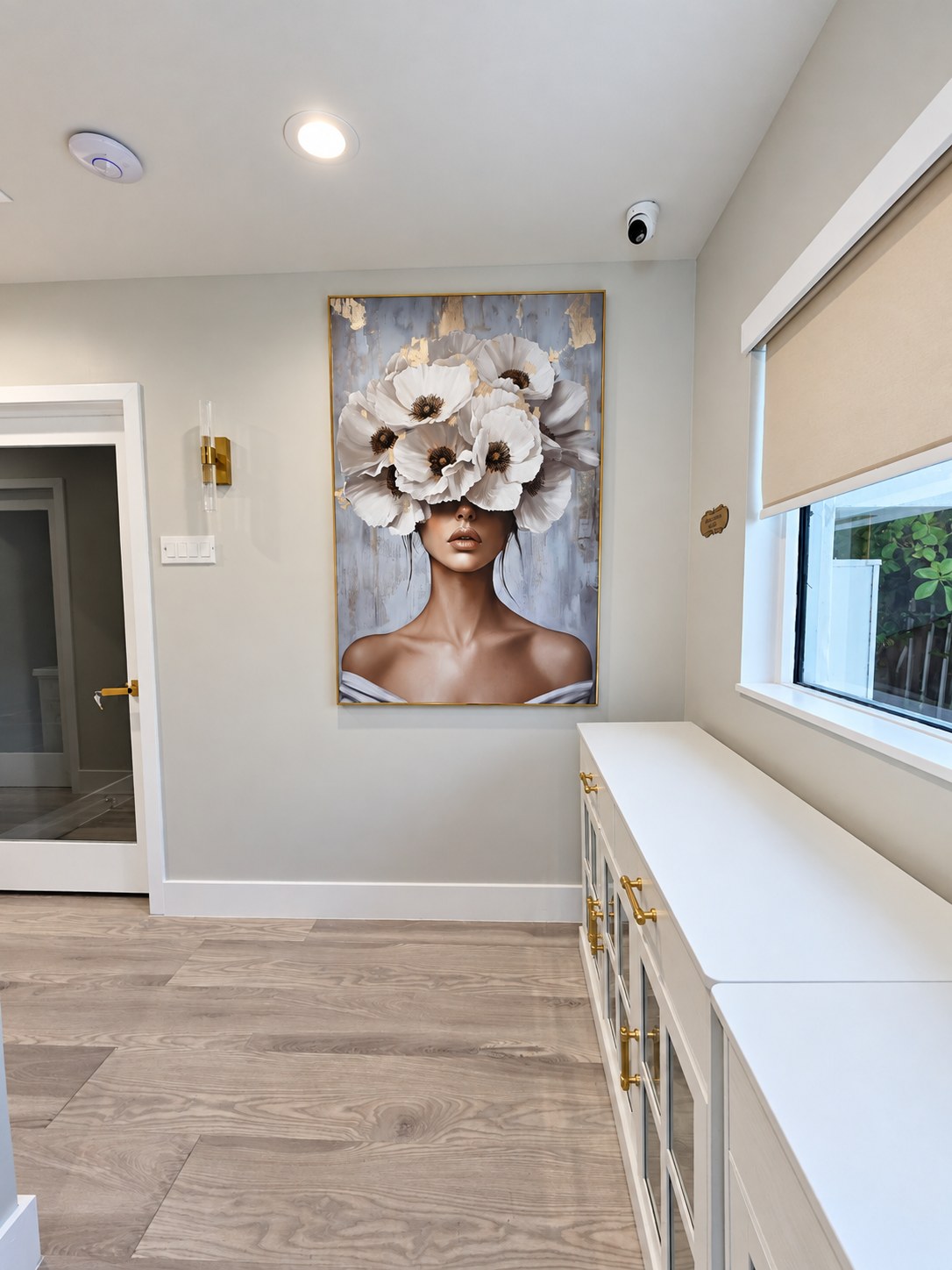Hallway with a white credenza, a gold-framed portrait and a window