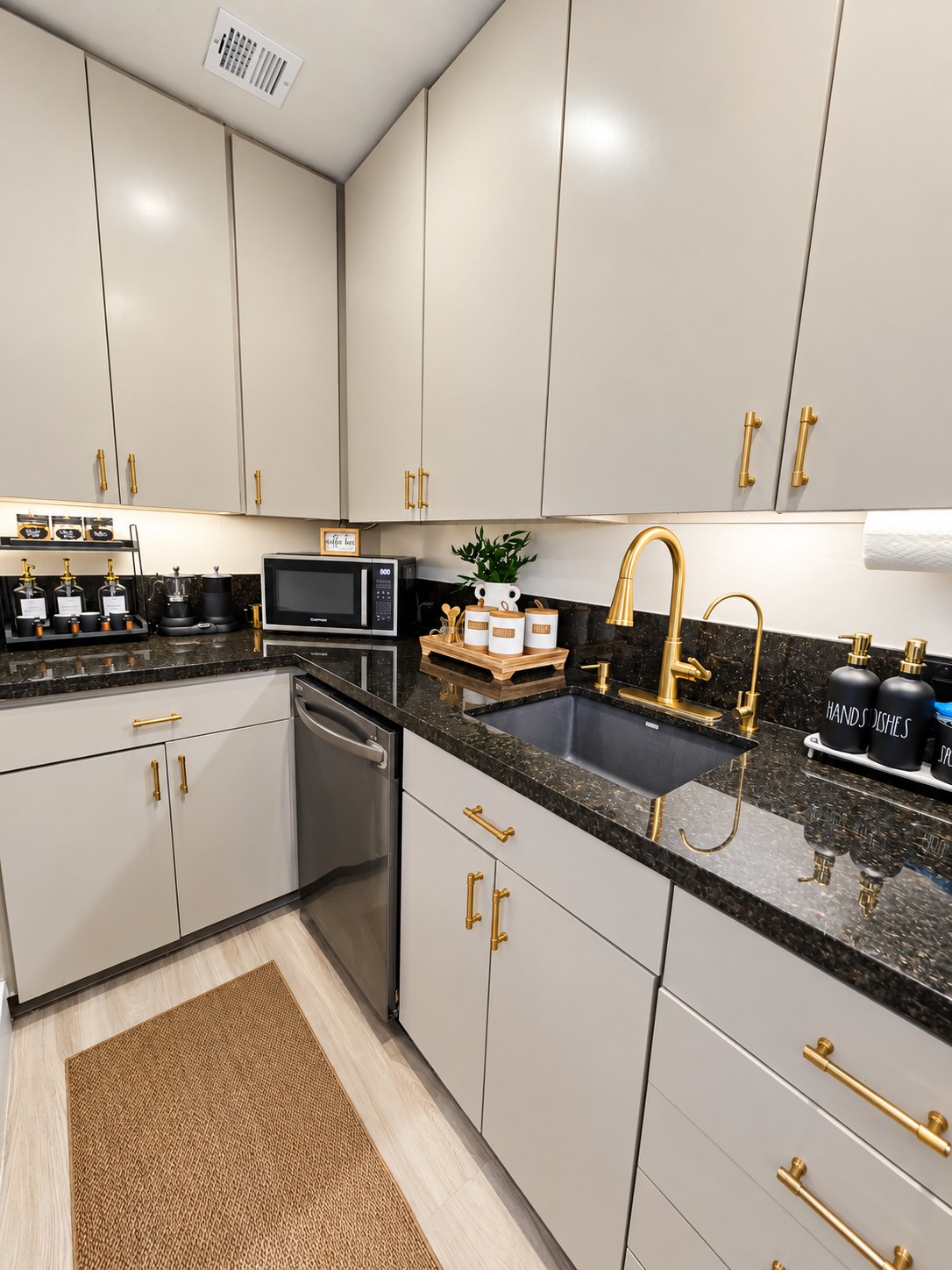 Kitchenette with dark granite counters, gold fixtures and a coffee station