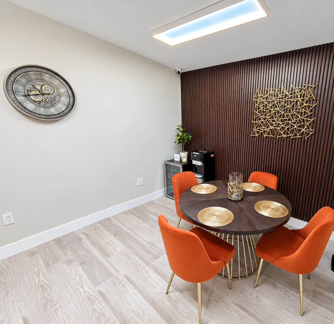Dining nook with a round table, four orange chairs and a dark slatted feature wall
